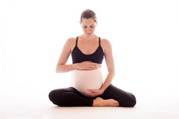 Woman sitting holding pregnant belly