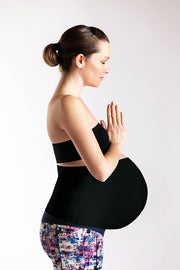 Pregnant woman with prayer hands wearing black belly band