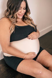 expectant mother sitting on floor holding belly